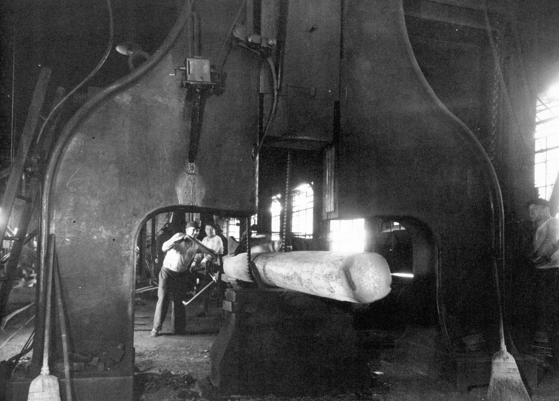 1950's photo of workers operating a giant press at Scot Forge; forging metal in a factory