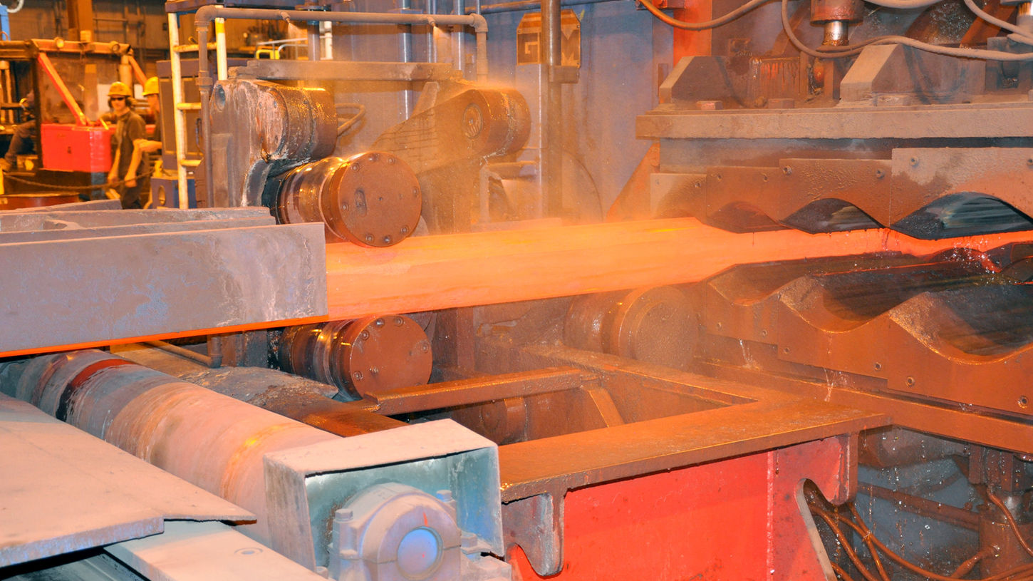 Bar being processed through the bar roller machine at Scot Forge