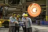 Slaes and blacksmiths collaborating on a spindle forging