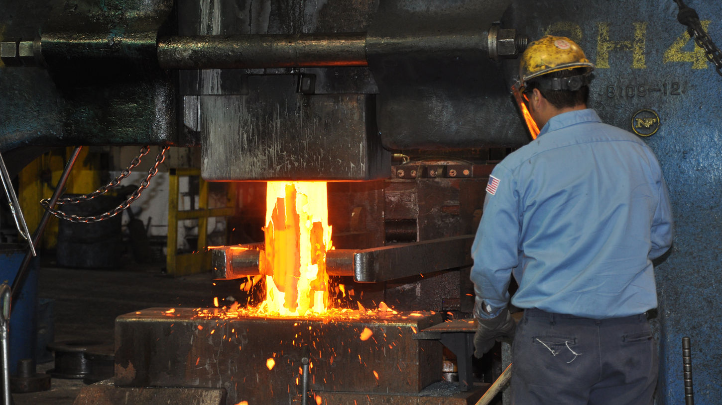 Worker upsetting a hot piece of metal in step one of the disc forging process